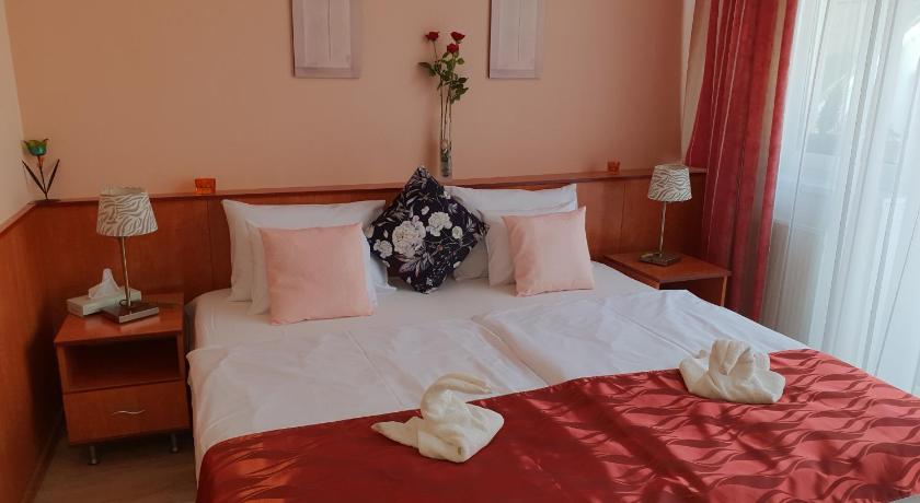 a bed with a white blanket and pillows on top of it, Hotel Isabell Gyor in Gyor