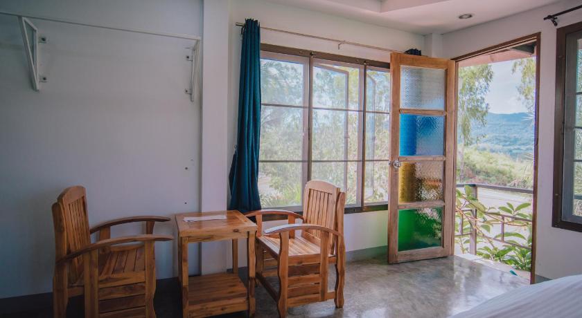 a room with a bed, chair, table and a window, Ob-Oon Khao Kho Resort in Khao Kho