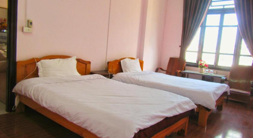 two beds in a room with a window, Thanh Ha Homestay Sapa in Sapa