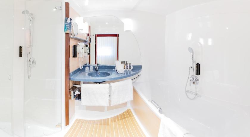 a bathroom with a sink, toilet and bathtub, NOVOTEL SUITES GENEVE AEROPORT in Vernier