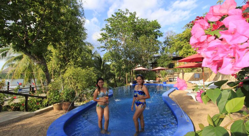 two people are playing in a pool on a sunny day, Discovery Island Resort and Dive Center in Palawan
