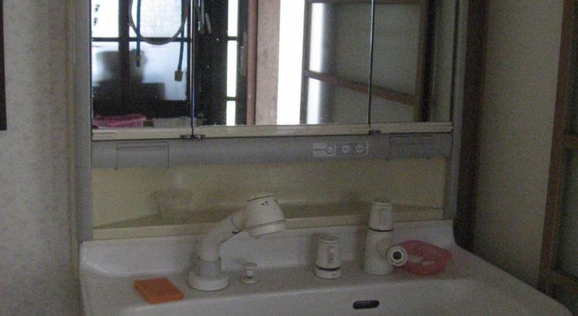 a white sink sitting under a mirror in a bathroom, Fujiyoshida Youth Hostel in Fujikawaguchiko