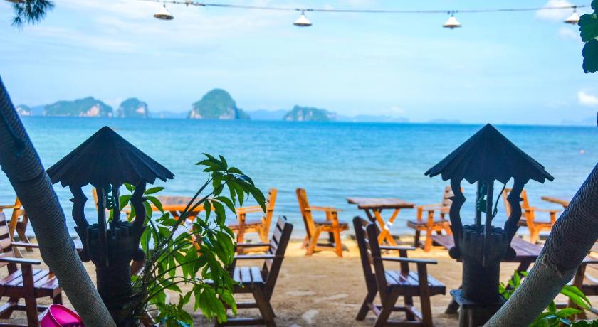 a beach area with chairs, tables and umbrellas, Baan Tubkaek Hotel in Krabi