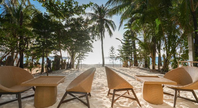 a row of beach chairs sitting on top of a sandy beach, Signature Boracay Blue (Formerly La Banca House) in Boracay Island