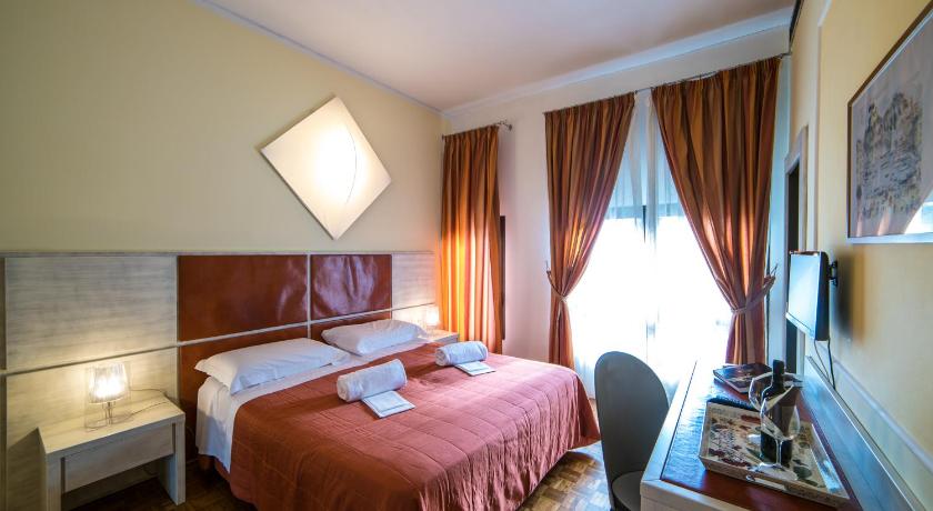 a hotel room with a bed, chair, lamp and window, La Vecchia Cartiera in Colle di Val d' Elsa