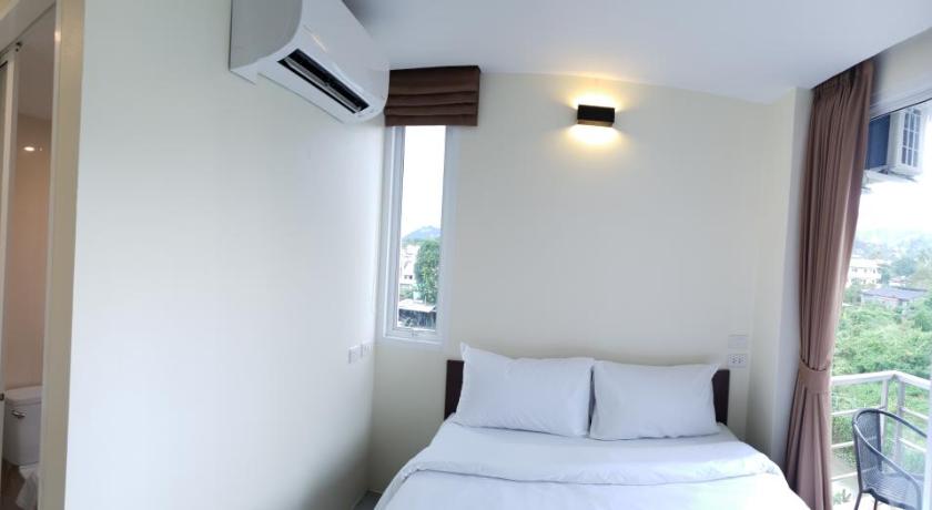a bedroom with a white bed and white walls, Top Hostel Samui. in Koh Samui