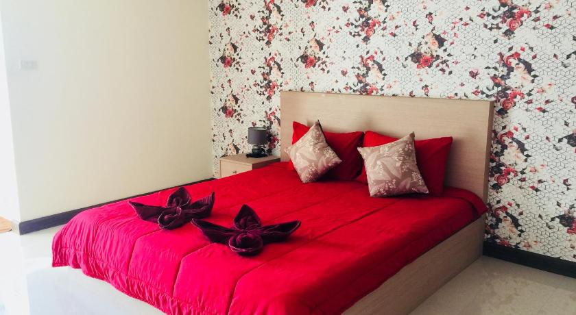 a bed with two pillows and a red blanket, Thani Residence in Chonburi