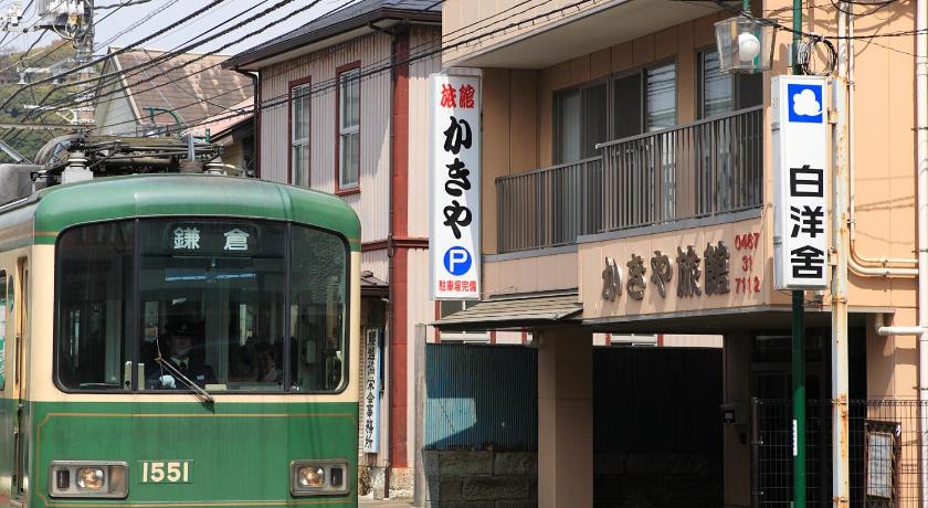 a green and white bus parked on the side of a street, Kakiya Ryokan in Kamakura