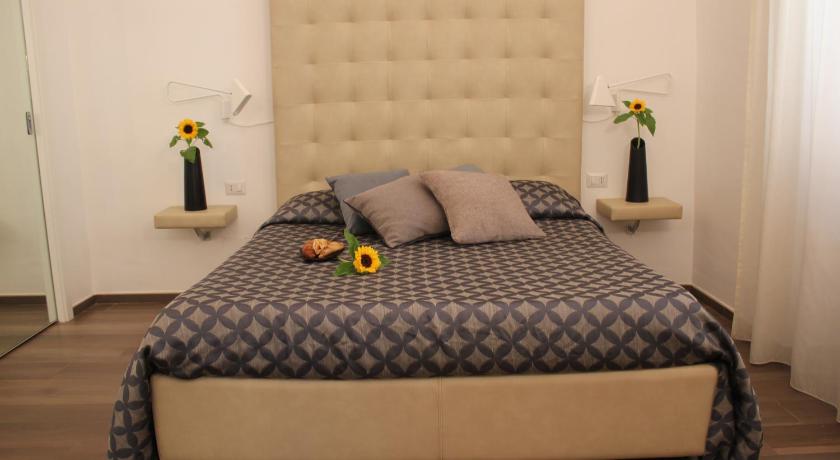 a bed with a white bedspread and pillows, B&B La Dimora in Corato