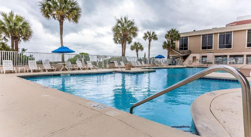 a swimming pool with a blue umbrella on top of it, Ocean Crest Inn and Suites in Myrtle Beach (SC)