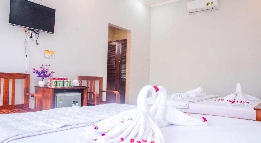 a hotel room with a bed and a dresser, Anna Nguyen Resort in Phu Quoc Island