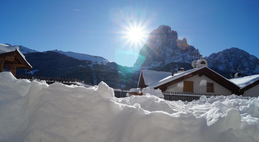 a snow covered mountain with a view of a city, Apartments Salieta in Santa Cristina In Val Gardena