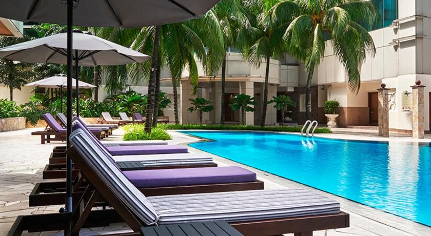 a patio area with a pool, chairs, and a bench, Pullman Kuala Lumpur City Centre Hotel and Residences Hotel in Kuala Lumpur