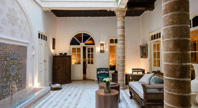 a living room filled with furniture and a large window, Riad Emotion in Essaouira