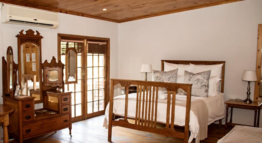 a bedroom with a bed and a dresser, Beaufort Manor Country Lodge in Beaufort West