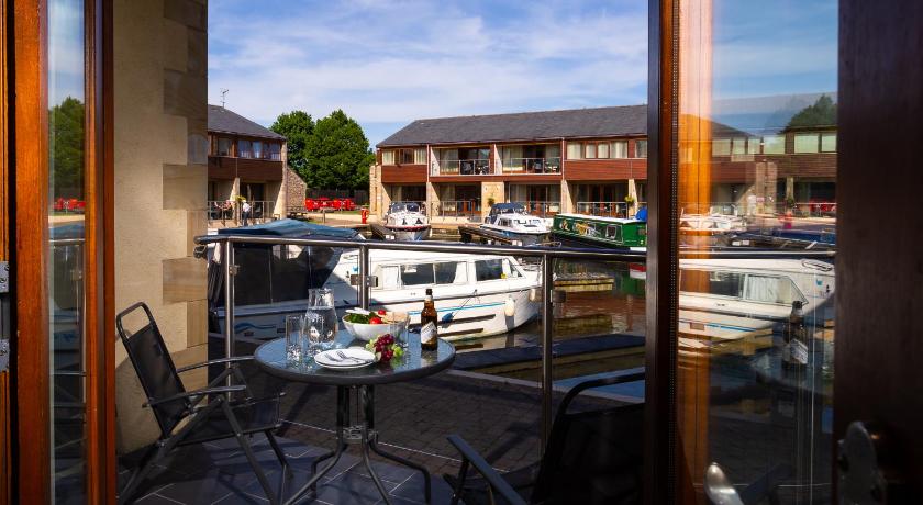 a boat sitting in a harbor next to a building, Tewitfield Marina in Over Kellet