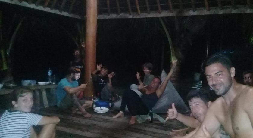 a large group of people sitting around a picnic table, Castaway Surf Retreat 1 in Sekongkang Bawah