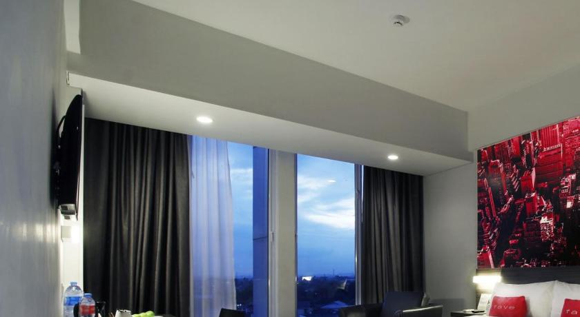 a hotel room with a large bed and a large window, favehotel Pekanbaru in Pekanbaru