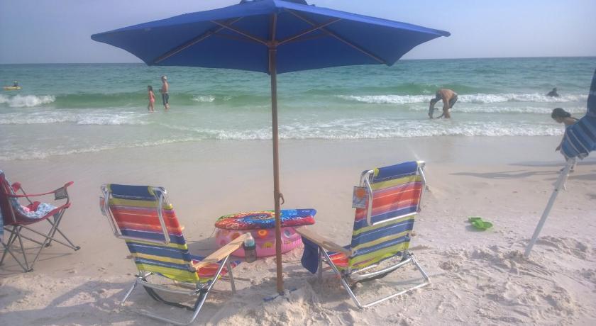 a beach area with chairs and umbrellas on the sand, Sandestin Resort Luau by Tufan in Destin (FL)