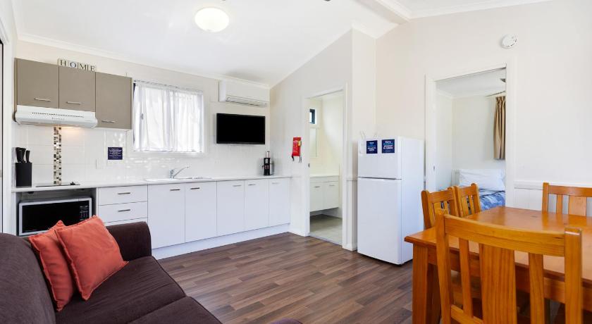 a living room filled with furniture and a kitchen, Goulburn South Caravan Park Cabin in Goulburn