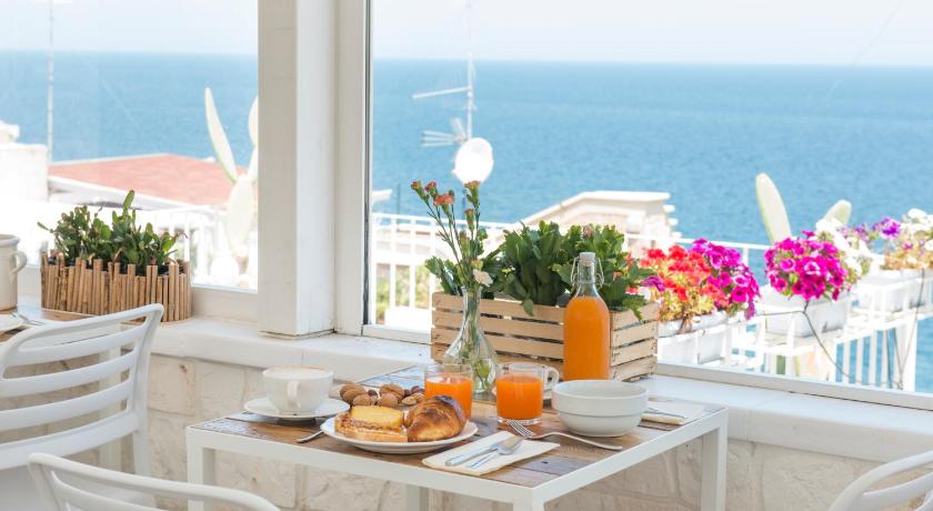 a table with a glass of orange juice on top of it, Santo Stefano Home & Breakfast in Polignano a Mare