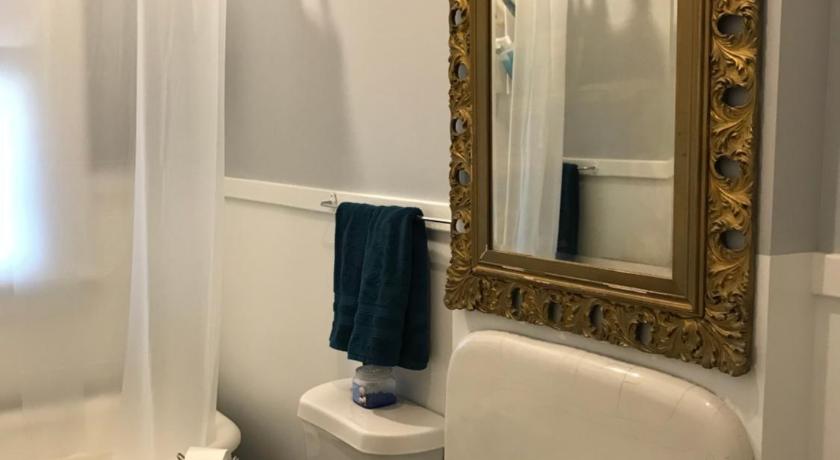 a bathroom with a sink, toilet and mirror, Vineyard Mansion B&B in St. Joseph (MO)