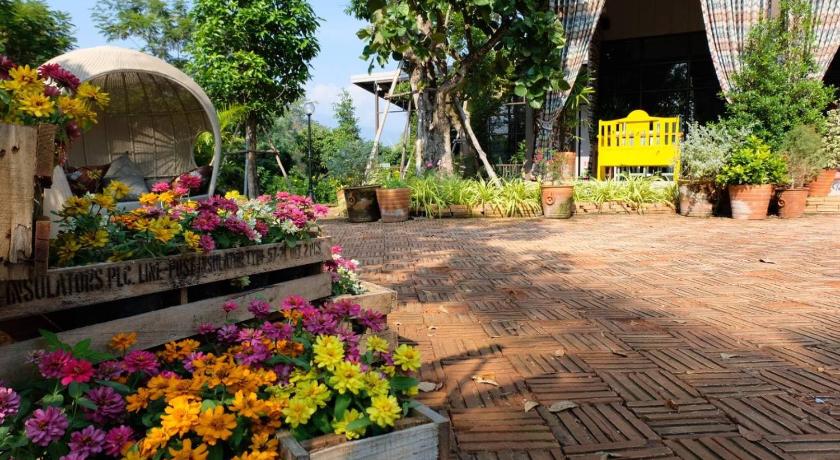 a garden filled with lots of flowers on a sunny day, Thanburi Resort in Chom Thong