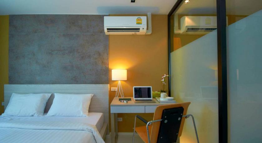 a bedroom with a bed and a desk, The Present Sathorn in Bangkok