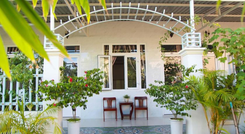 a patio area with a table, chairs, and a balcony, Son Tra Guesthouse in Phan Thiet