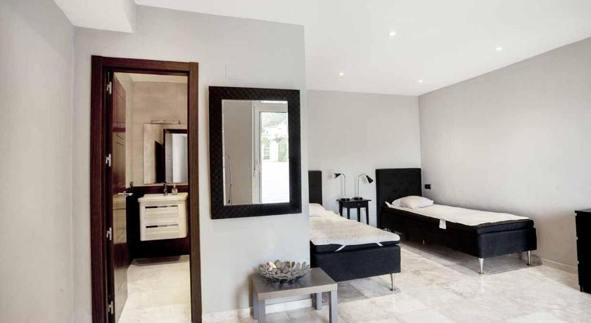 a room with a bed, a chair and a mirror, Villa Frigiliana San Rafael in Nerja