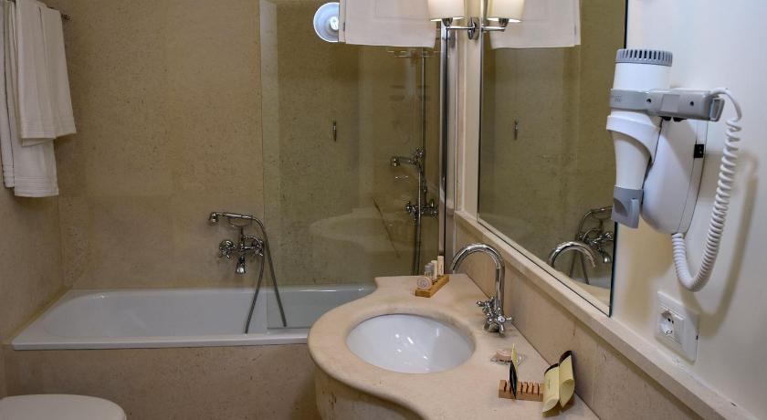 a bathroom with a sink, toilet and shower, Torrione Hotel in Reggio Calabria