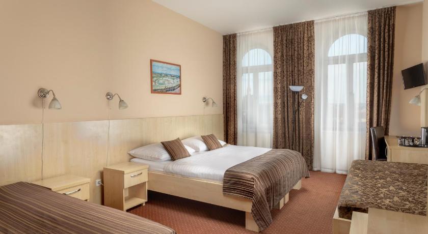 a hotel room with a bed, chair, and a television, Prague Centre Plaza Hotel in Prague