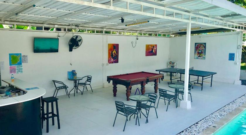 a patio area with tables, chairs and umbrellas, Samui Backpacker Hotel in Koh Samui