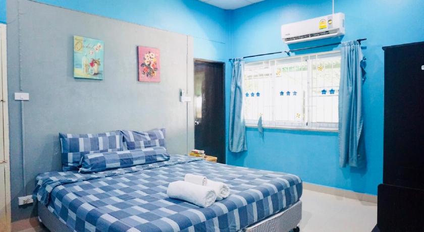 a bed room with a blue bedspread and a blue wall, PS 35 Village in Phuket