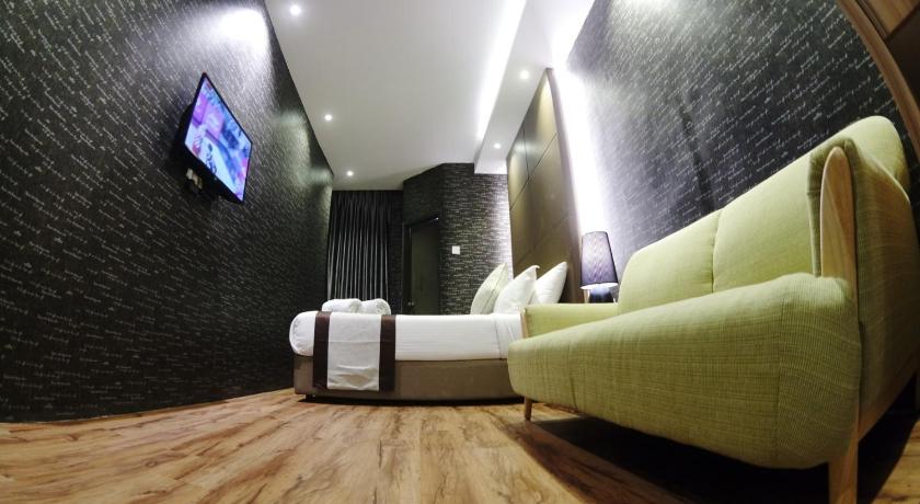 a living room with a couch and a television, HereHotel in Johor Bahru