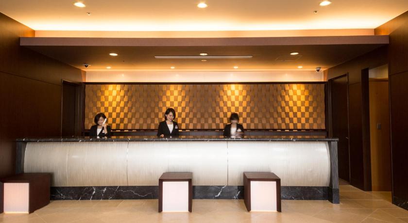two people are sitting at a bar in a hotel lobby, ANA Crowne Plaza Yonago in Yonago