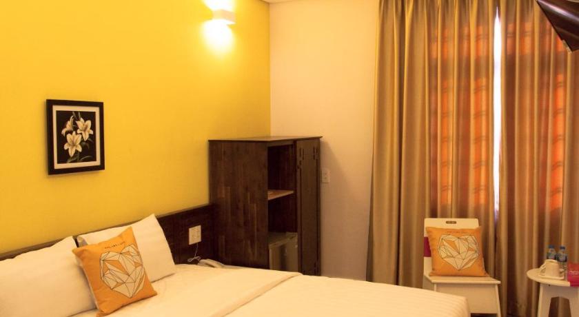 a hotel room with a bed and a television, Spring Hotel in Bình Dương