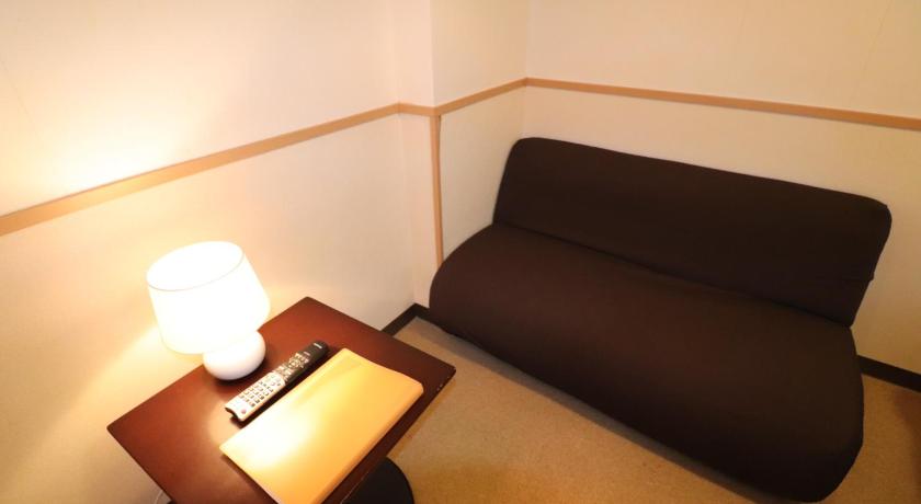 a living room with a couch, coffee table and a lamp, Hotel Yuyukan Center of Kabukicho, Shinjuku in Tokyo