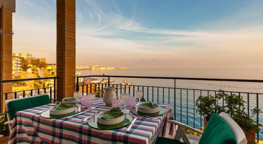 a dining room table with a balcony overlooking the ocean, O-House Posillipo by Napoliapartments in Naples