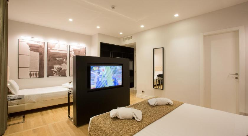 a hotel room with a television and a bed, Floris Hotel in Rome