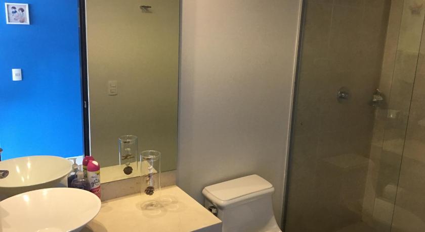 a bathroom with a toilet, sink, and mirror, Napoles Condo Suites in Mexico City