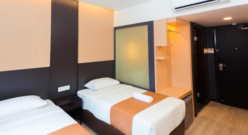 a hotel room with two beds and a television, Icon Hotel in Segamat