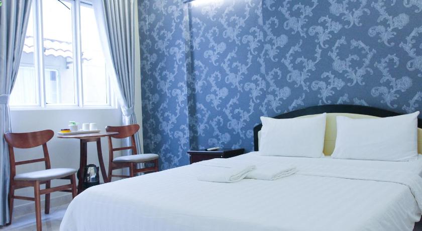 a hotel room with a bed and a chair, Violet Star Hotel & Spa in Ho Chi Minh City