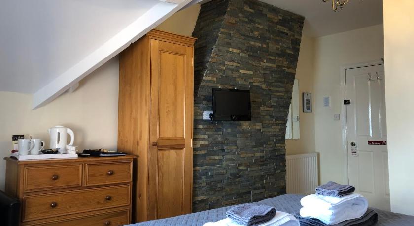 a hotel room with a bed and a television, The Whalebone Arch in Whitby