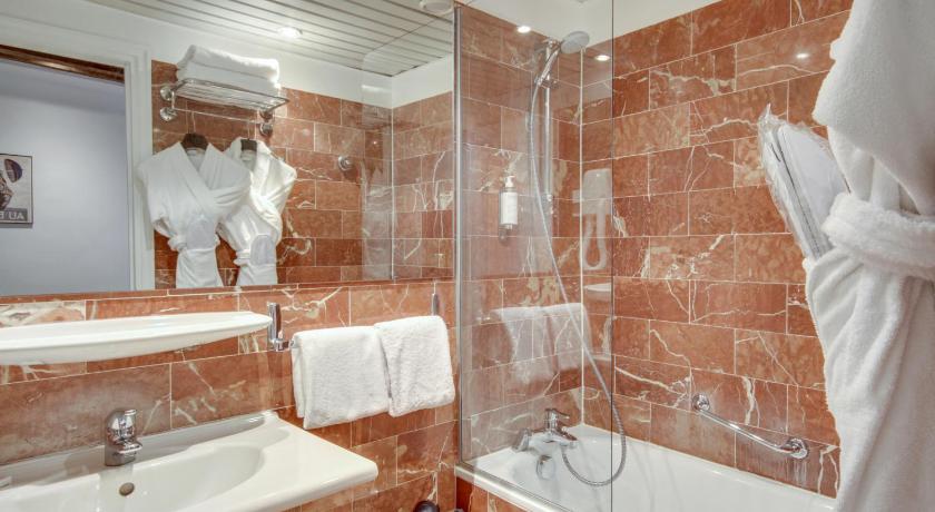 a bathroom with a tub, sink and mirror, Sevres Saint Germain Hotel in Paris