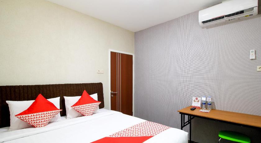 a hotel room with two beds and two nightstands, Super OYO 217 A1 Hotel in Surabaya