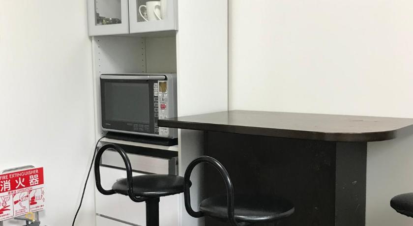 a kitchen with a microwave and a refrigerator, Guesthouse En in Omihachiman