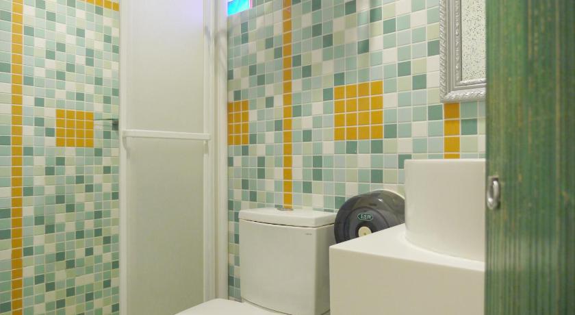 a white toilet sitting next to a bath tub, Sin Sin Hotel in Kenting