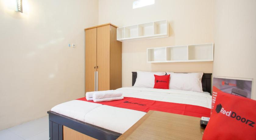 a hotel room with a bed and a desk, RedDoorz Syariah near UNTAG Banyuwangi in Banyuwangi