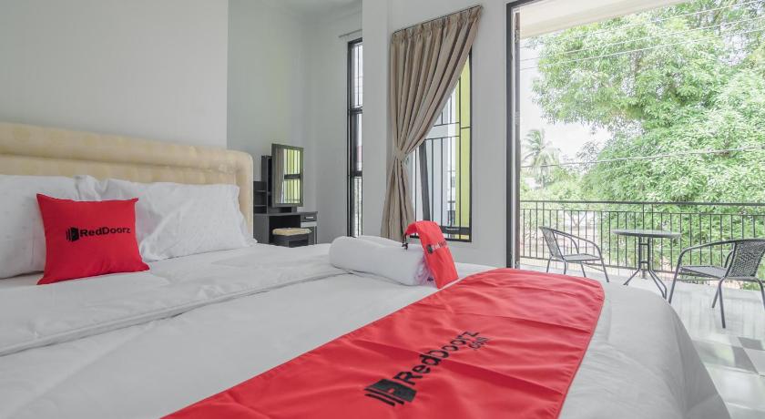 a hotel room with a large bed and a large window, RedDoorz near Sultan Thaha Airport Jambi in Jambi